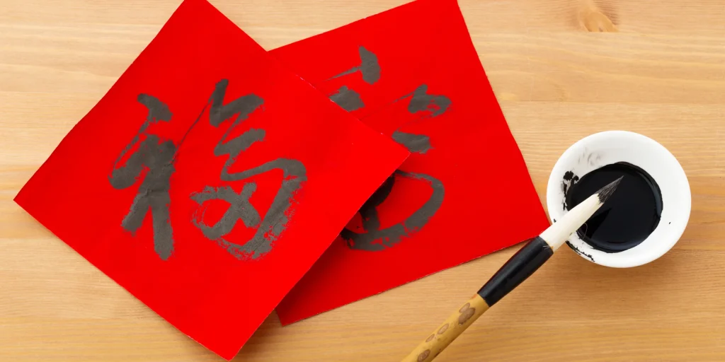 Celebrating Lunar New Year in the Classroom - the picture is of the Chinese character for 'fortune' in calligraphy on red paper with and ink brush next to it